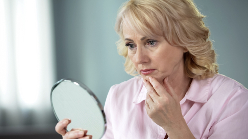 Unhappy woman looking in mirror