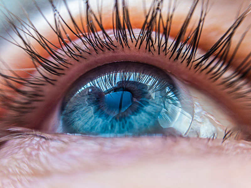 Close up of blue eye with contact lens inserted