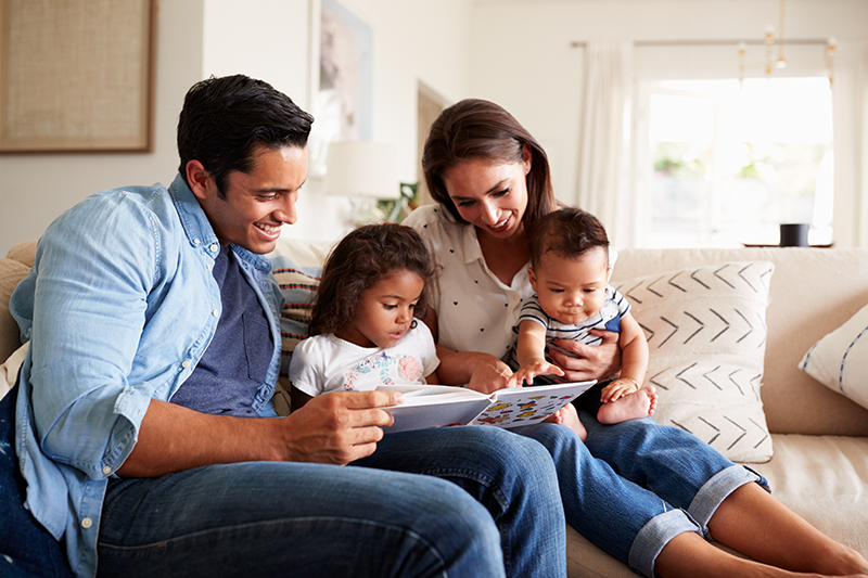 Young family reading on couch