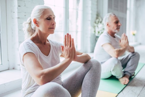 Senior couple at home in yoga meditation