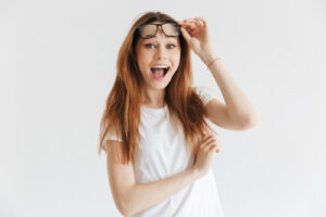 woman smiling and holding glasses