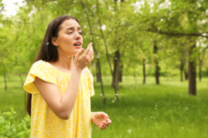 woman in field with trees and flowers in background