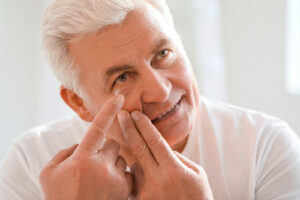 Elderly man inserting contacts