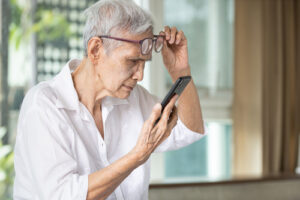 older woman trying to read cell phone