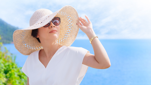 Woman outside wearing sunglasses and sun hat