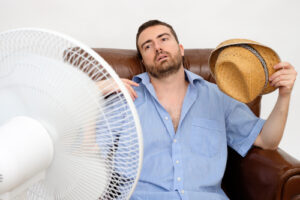 man sitting in front of fan