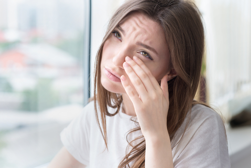 Woman rubbing her irritated eye