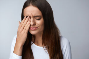 Woman wiping eye from dry eye 